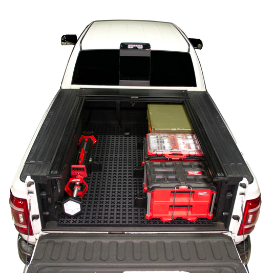 Tmat in Ram 2500 truck bed with Milwaukee Packouts, a Rtic cooler, and Milwaukee shop light.
