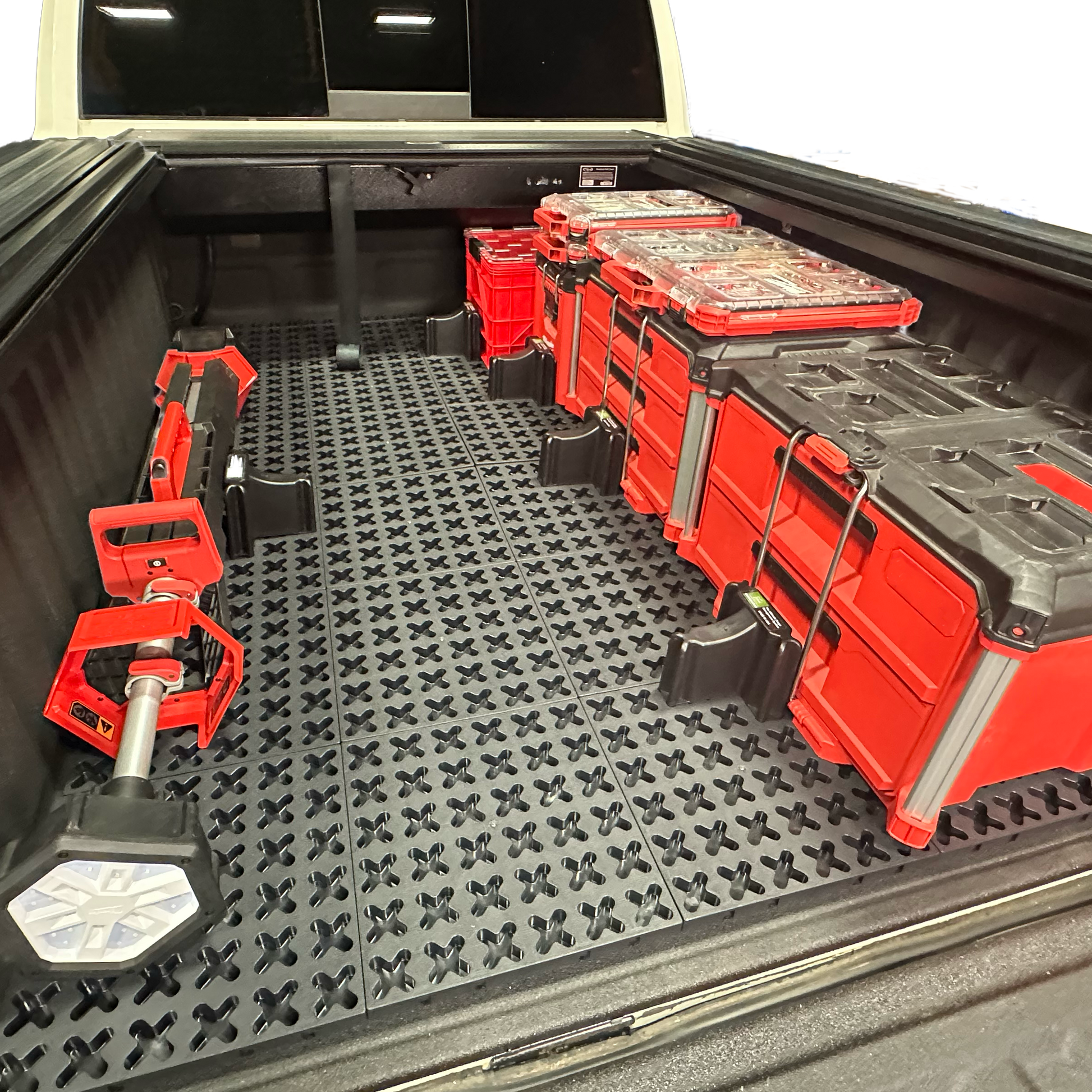 Tmat grid cargo system securing Milwaukee Packout tool boxes and a Milwaukee shop light.