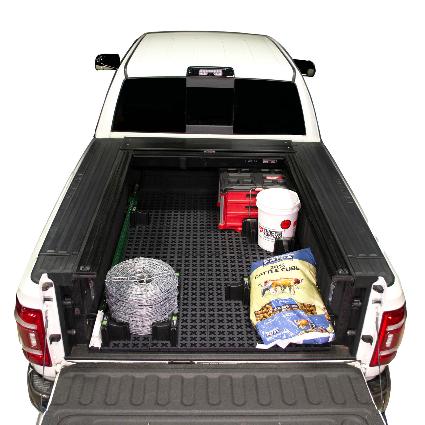 Tmat Cargo System in a Ram pickup bed with a bucket, t-posts, barb wire, a bag of cattle feed, and Milwaukee Packout toolbox.