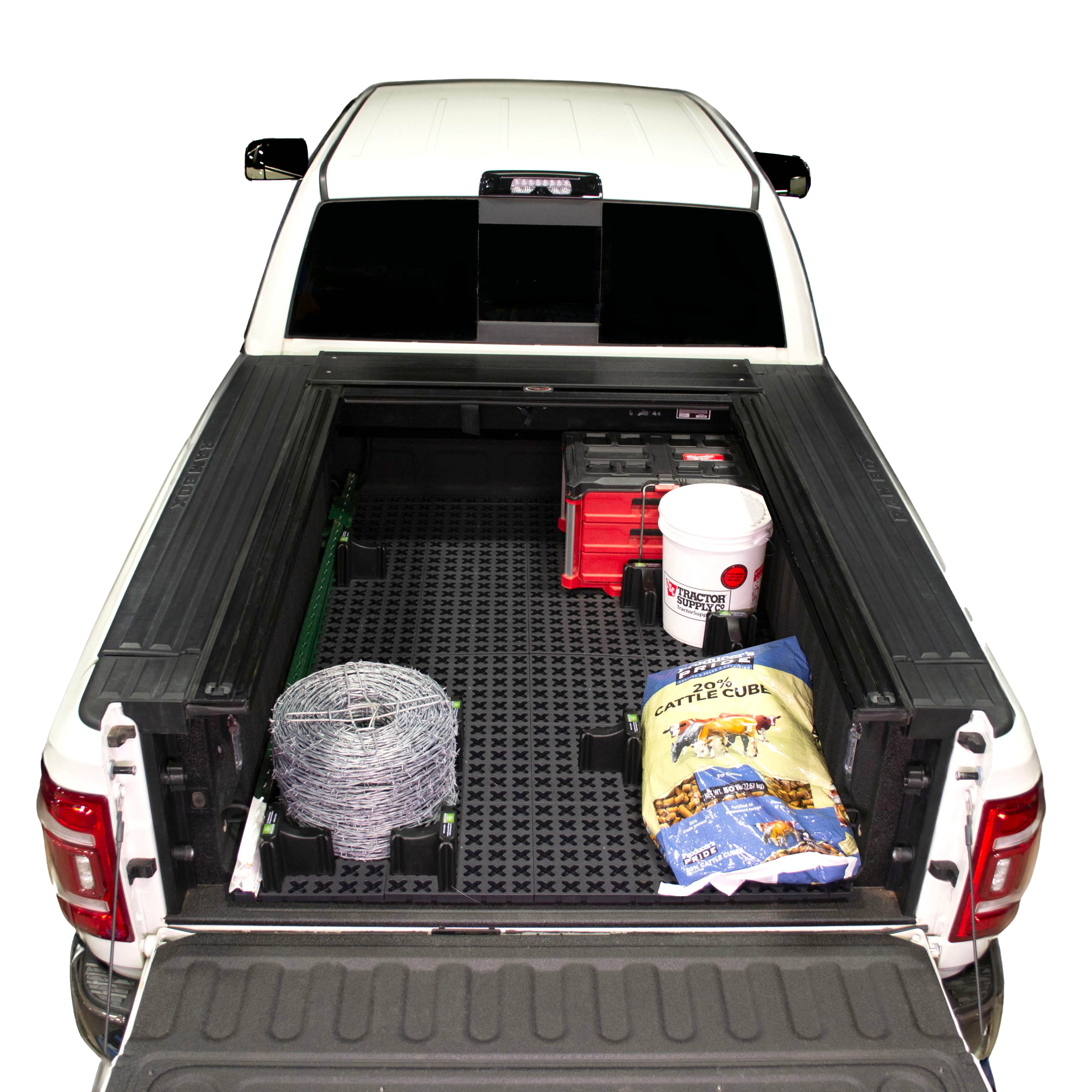 Tmat Cargo System in a Ram pickup bed with a bucket, t-posts, barb wire, a bag of cattle feed, and Milwaukee Packout toolbox.